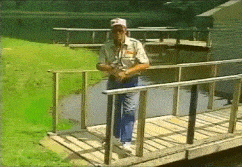 a man standing on a wooden bridge over a river