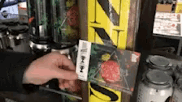 a person is holding a plastic bag with a sticker that says ' nz ' on it .