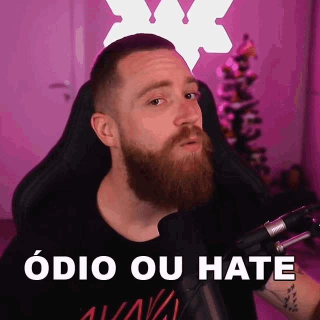 a man with a beard is sitting in front of a microphone and the words odio ou hate are above him