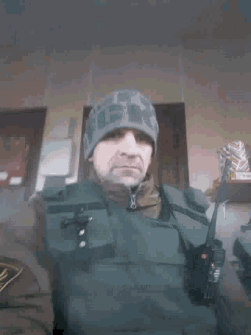 a man wearing a military uniform and a beanie with the letter g on it