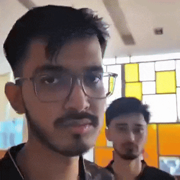 a man wearing glasses and a beard looks at the camera