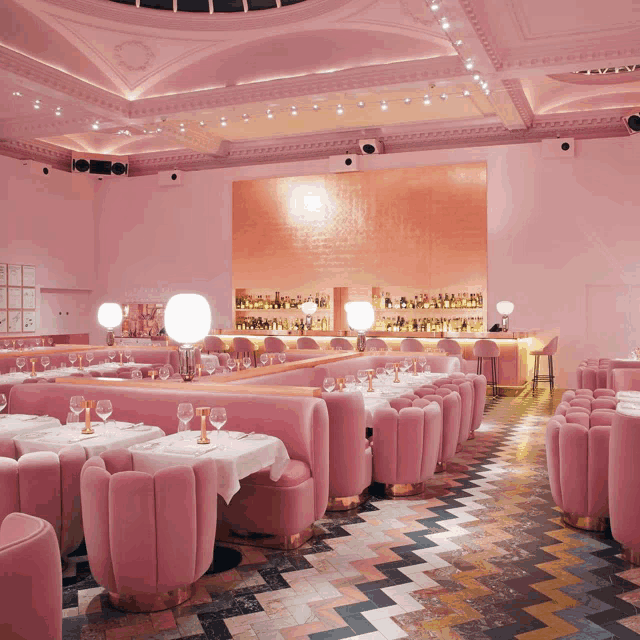 a pink restaurant with tables and chairs and a bar