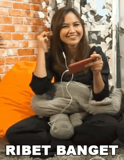 a woman wearing headphones is sitting on a bean bag chair playing a video game .
