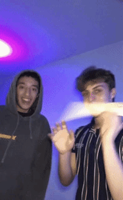 two young men are posing for a picture with one wearing a hoodie that says ' abercrombie & fitch ' on it