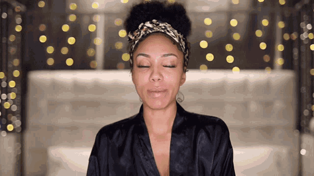 a woman with her eyes closed is wearing a headband