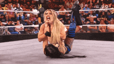 two women are wrestling in a ring with the us written on the bottom