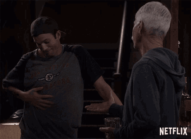 a man pointing at another man with a netflix logo behind him