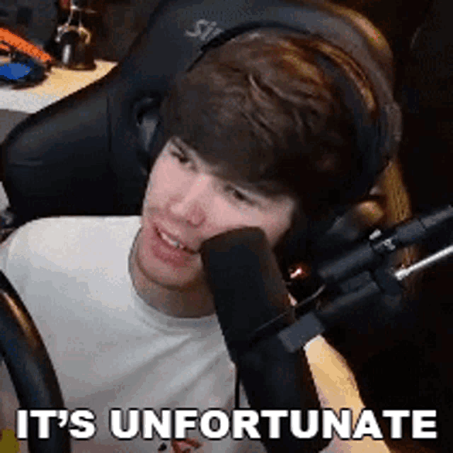 a man wearing headphones is sitting in front of a microphone and saying it 's unfortunate .