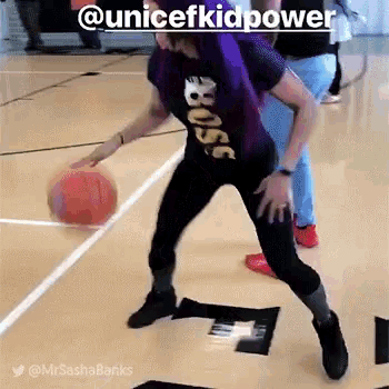a girl with purple hair is playing basketball on a court