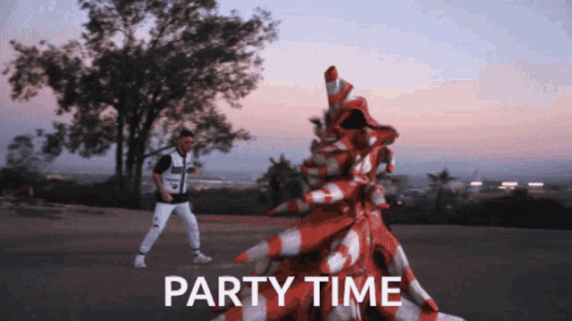 a man is dancing in front of a pile of traffic cones with the words party time written below him