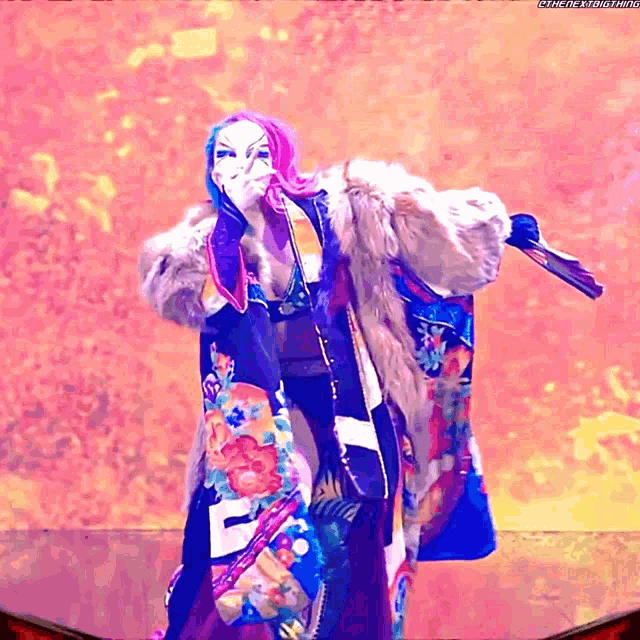 a woman in a colorful kimono is holding a fan and has the letters eee on her chest
