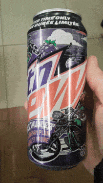 a person is holding a can of mtn dew with a motorcycle on it