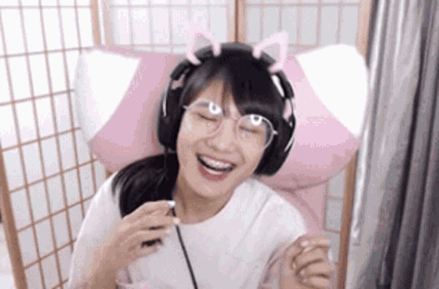a woman wearing headphones and glasses is smiling