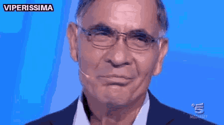 a man wearing glasses and a microphone with the words non sono il tipo below him