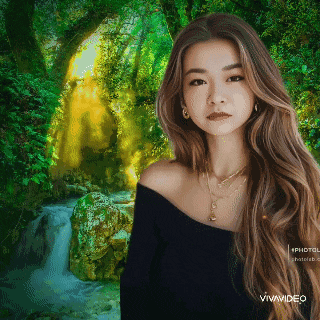 a woman with long hair is standing in front of a waterfall in the woods