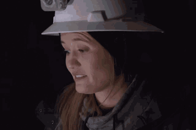 a woman wearing a hard hat making a sad face