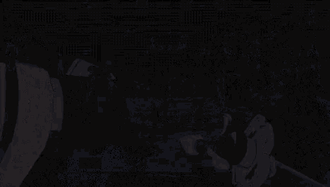 a close up of a person holding a sword in their hand with a black background .