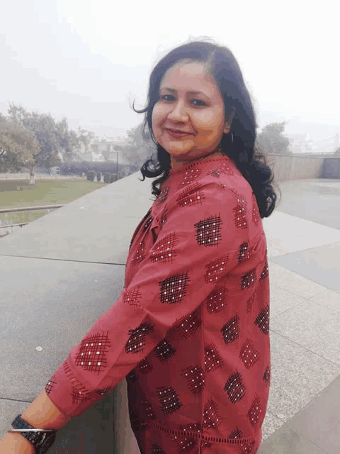 a woman in a red shirt with a pattern on it