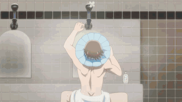 a man is taking a shower in a bathroom with a towel around his head