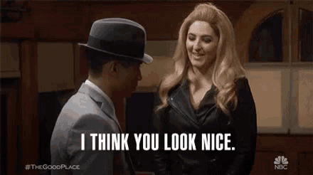 a man and a woman are standing next to each other and the woman is saying `` i think you look nice . ''