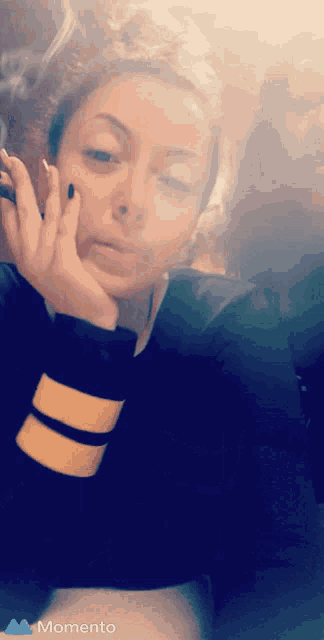 a woman smoking a cigarette with the word momento on the bottom