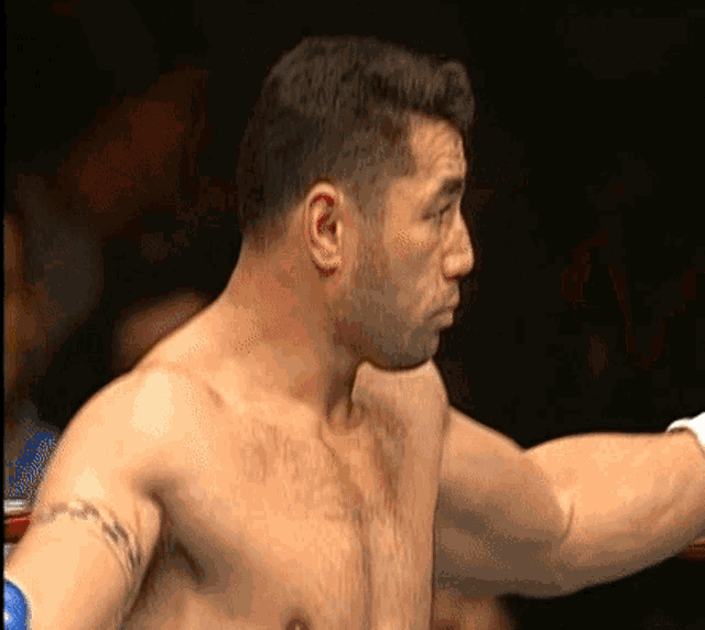 a shirtless boxer with a tattoo on his arm