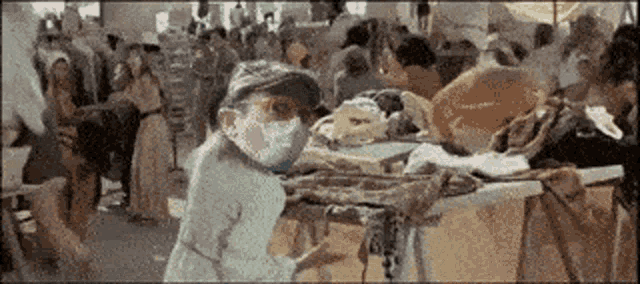 a person wearing a mask is standing in front of a crowd of people