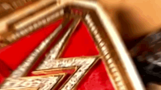 a close up of a wrestler 's belt on a red surface .