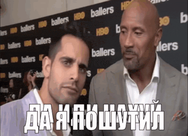 two men are talking in front of a wall that says ballers