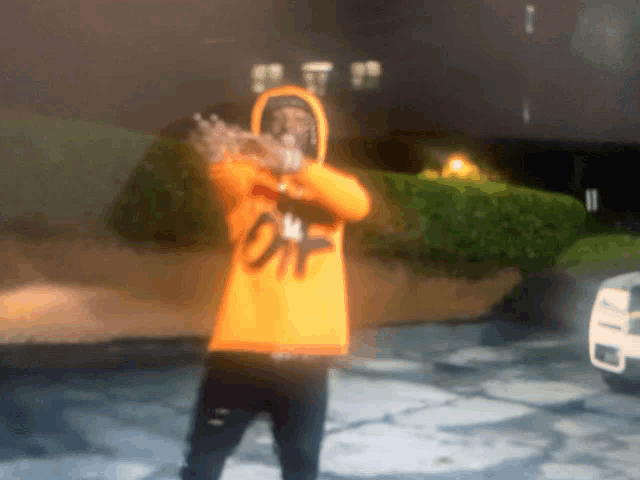 a person wearing an orange hoodie that says off