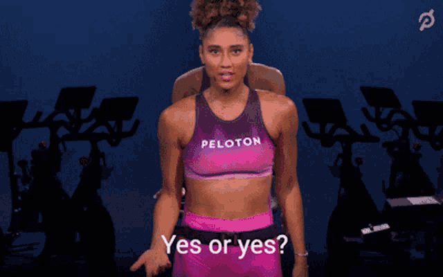 a woman wearing a peloton top is asking yes or yes