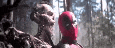 deadpool is holding a skeleton in his hands in the woods .