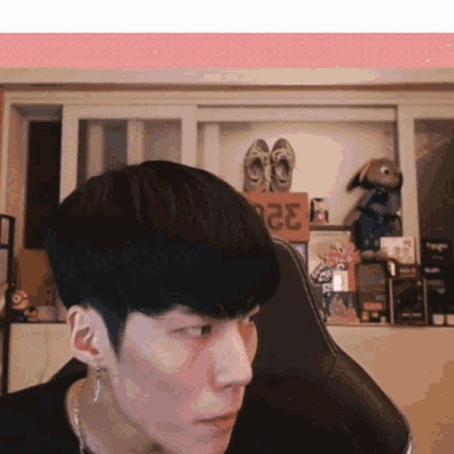a man is sitting in front of a shelf with a sign that says ' 2323 ' on it