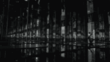 a black and white photo of a reflection of a city in a mirrored room .