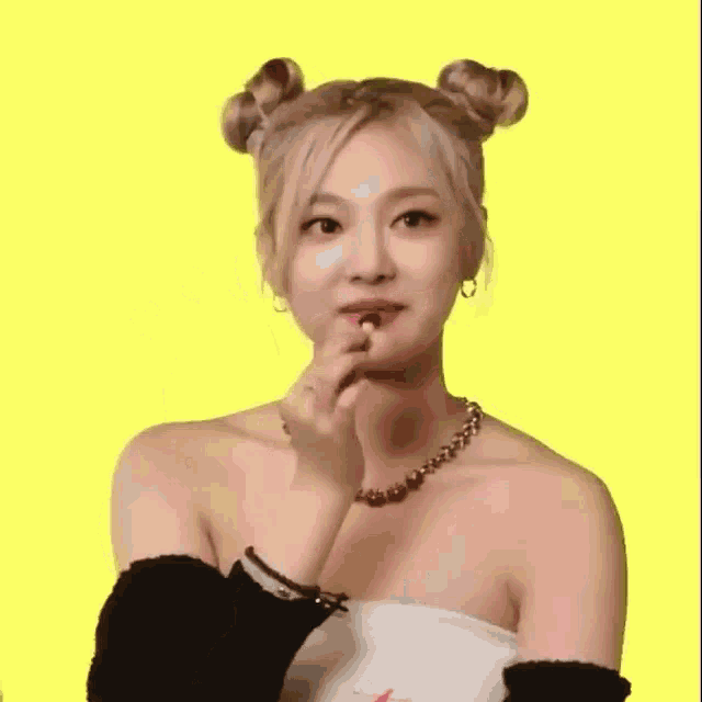 a woman with buns on her hair is clapping her hands .