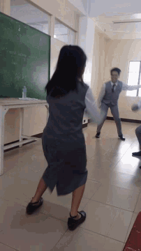 a girl stands in front of a blackboard that says " physics "