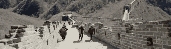 a group of people walking along the great wall of china .