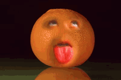 an orange with a face on it looks up at the camera
