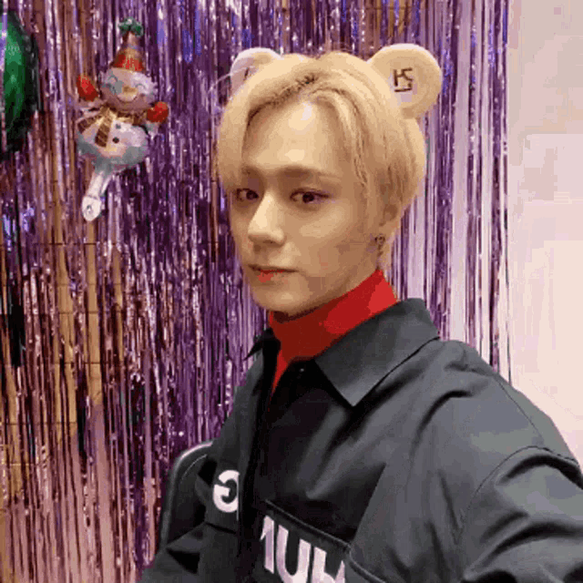 a young man wearing a bear ear hat and a shirt that says ' s ' on it