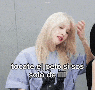 a woman with blonde hair is wearing a t-shirt that says tocate el pelo si sos solo de lili