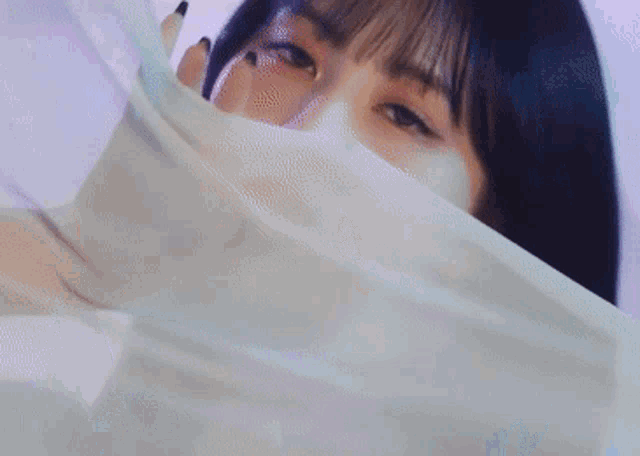 a close up of a woman 's face with a white cloth covering it