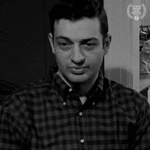 a man in a plaid shirt is looking at the camera .