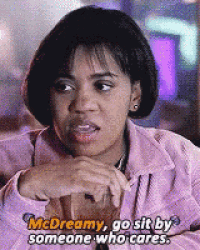 a woman in a pink jacket is sitting at a table and talking to someone who cares .