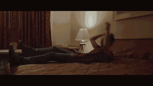 a man is laying on a bed with his legs crossed