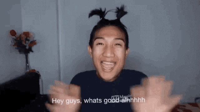 a man with pigtails on his head says " hey guys whats good ahhhh "