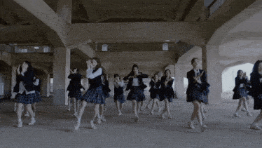 a group of girls in school uniforms are dancing in a dark hallway