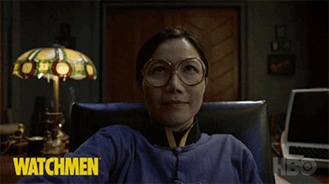 a woman wearing glasses is sitting in a chair and says " f * ck you ozymandias "