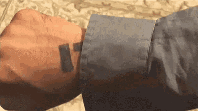 a close up of a person 's arm with a black sticker on it .