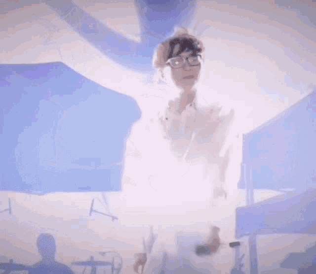 a person in a white shirt is holding a microphone in front of a blue background