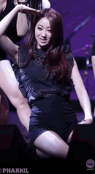 a woman in a black top and shorts is kneeling down